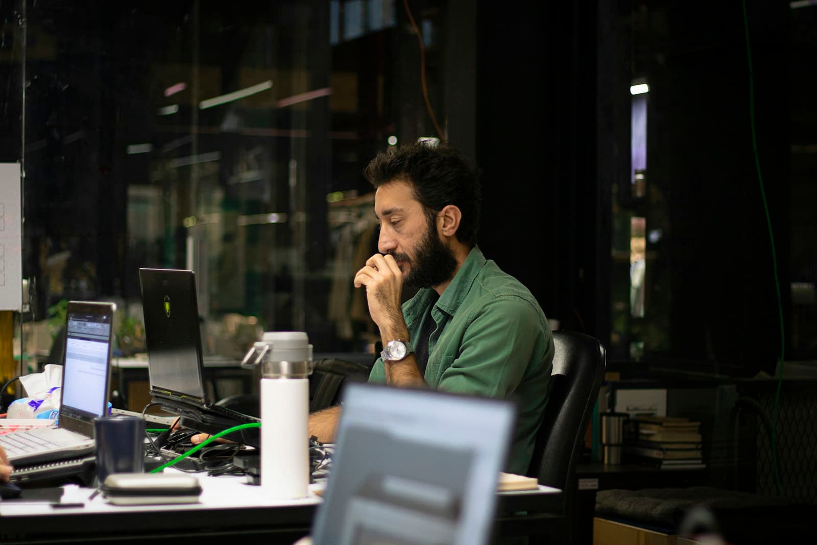 Un dirigeant travaille seul à son bureau en soirée, écran allumé.